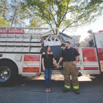 engaged couple holding hands and posing in front of fire truck in monroe louisiana