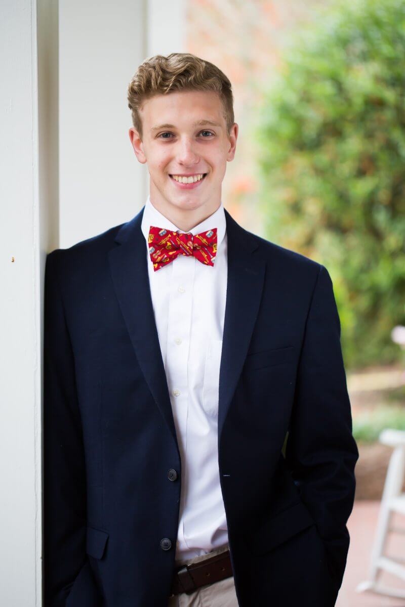 senior session portrait young man in sport coat smiling on front porch