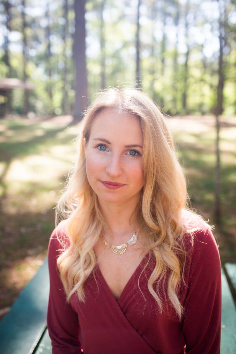 College Senior Session headshot of blonde woman in red dress on picnic table