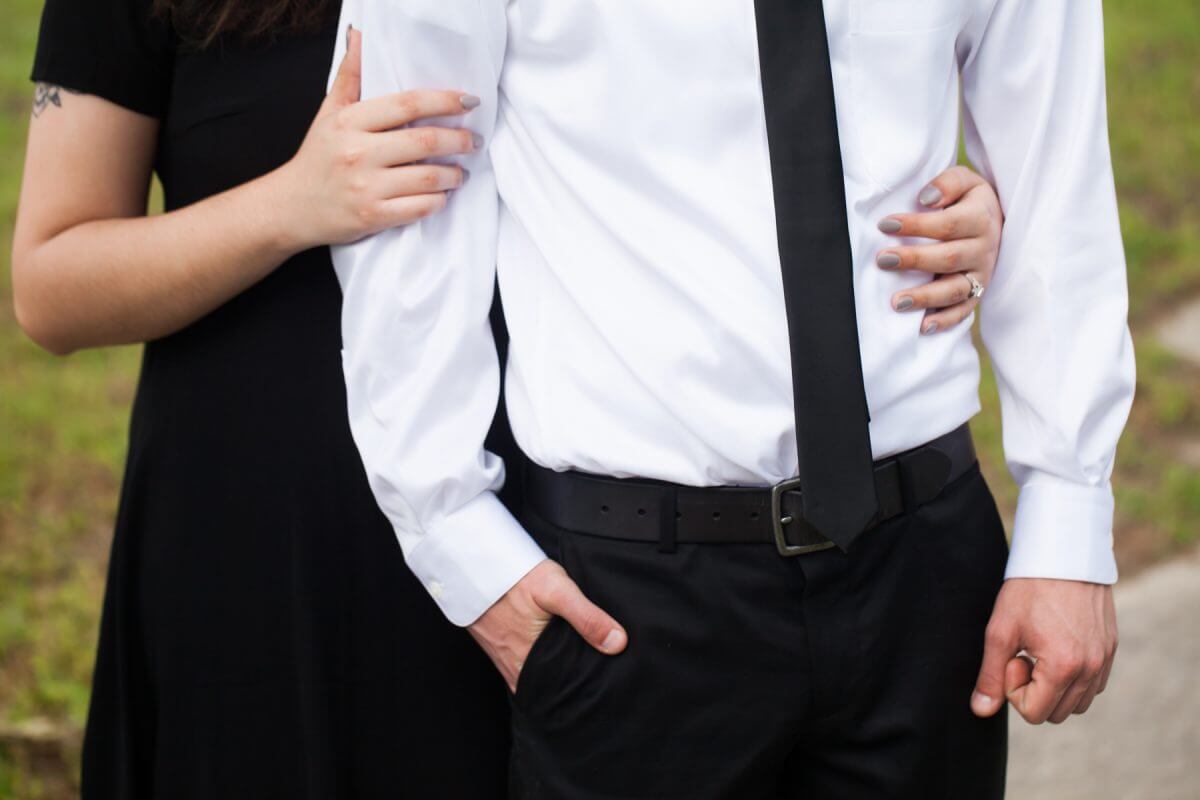 close up of woman's hands wrapped around man's waist and arm