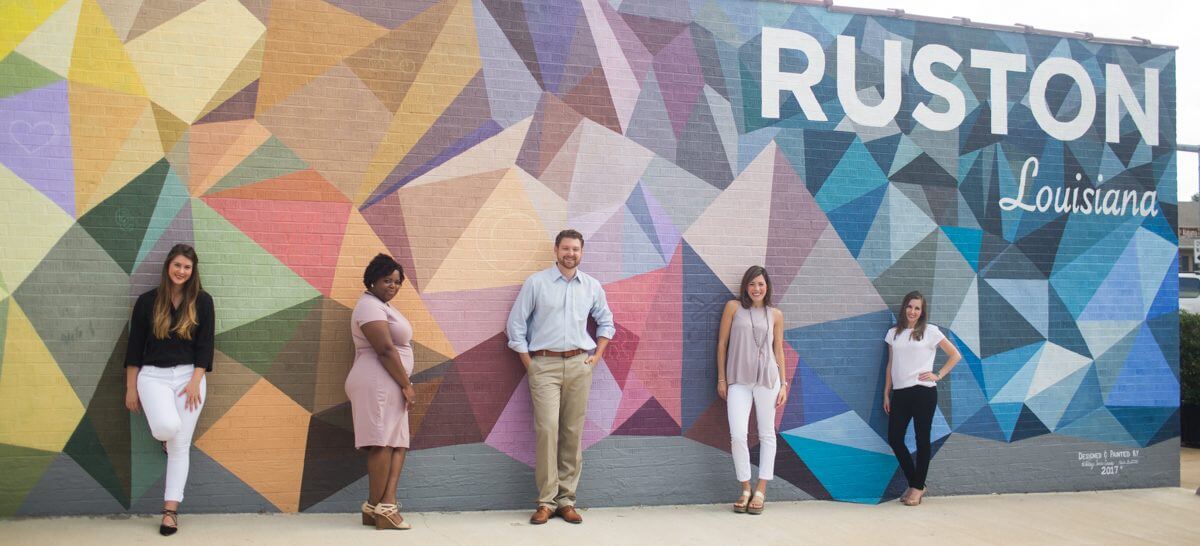 group of five individuals standing in front of mural in downtown Ruston, Louisiana