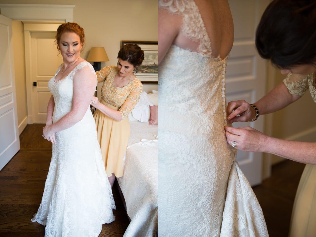mother of the bride helping beautiful red headed bride button her wedding dress