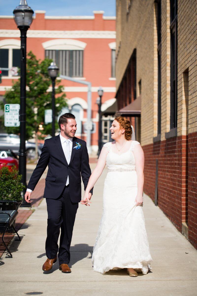 bride and groom in wedding attire walking down street in downtown Ruston, LA